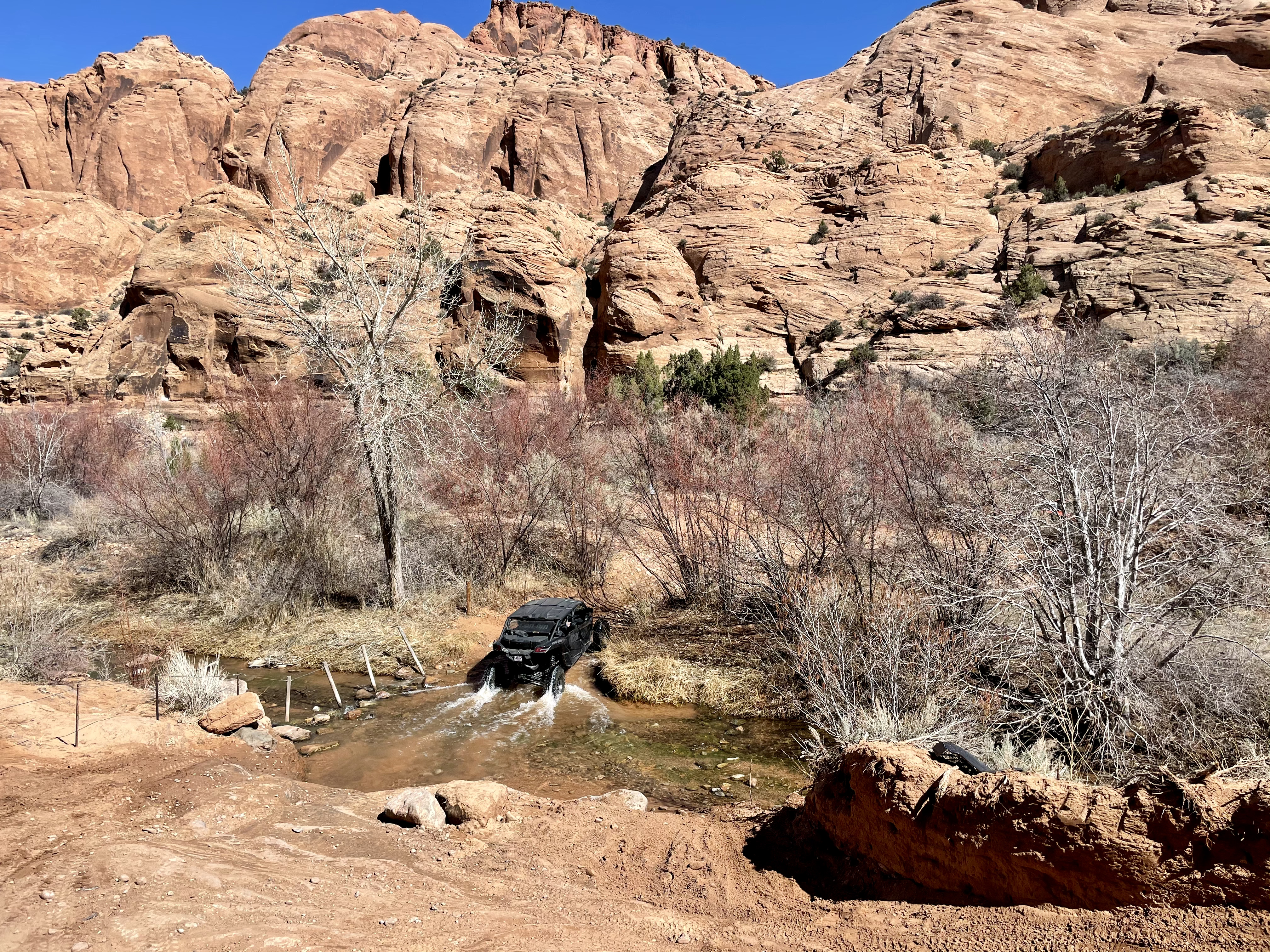 a large, four-person Can-Am side-by-side navigates a portion of Mill Creek that intersects with the Steel Bender trail