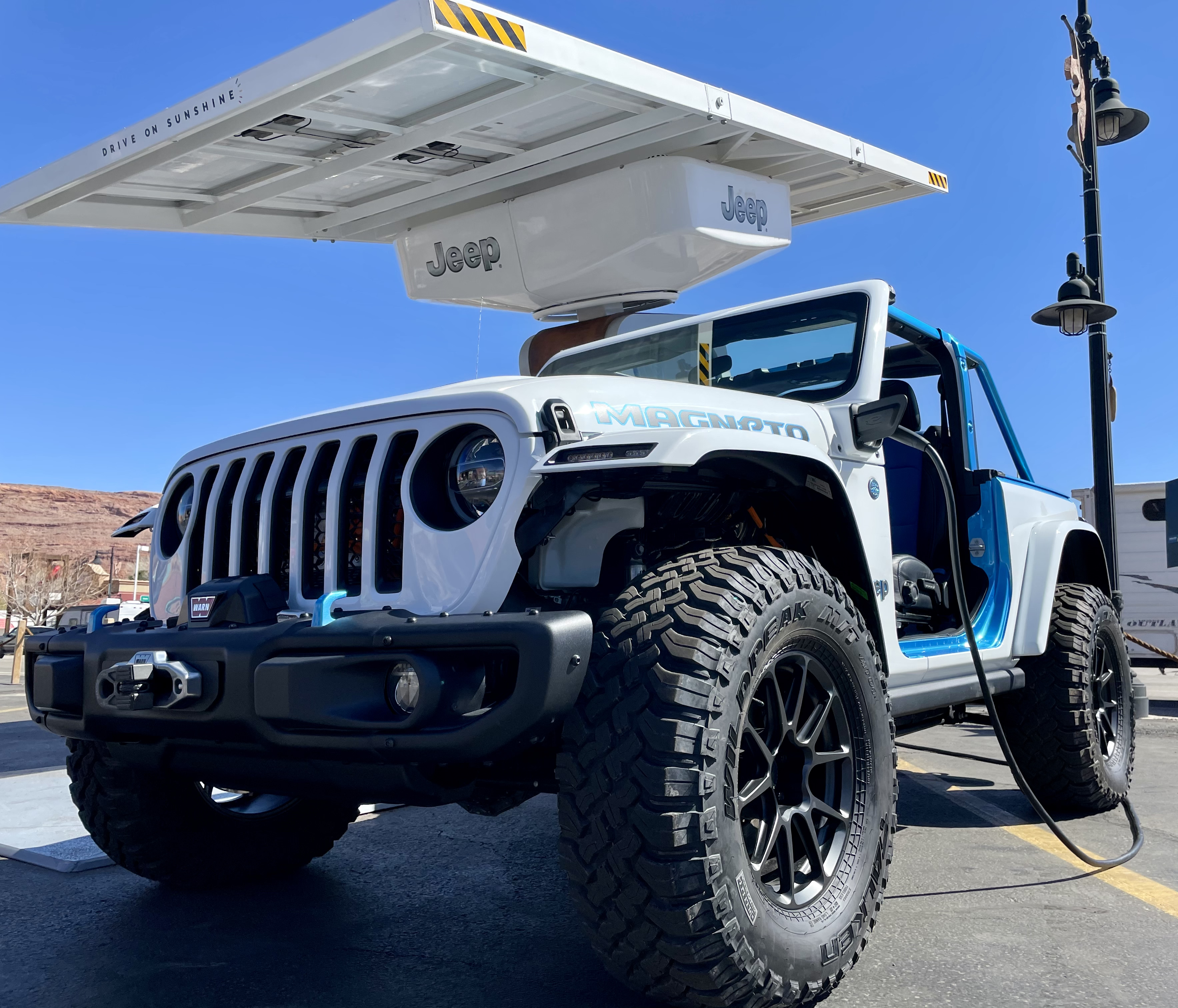 An up-looking angle at the Jeep Wrangler Magneto, a white Jeep with two seats — driver and passenger — and blue trim