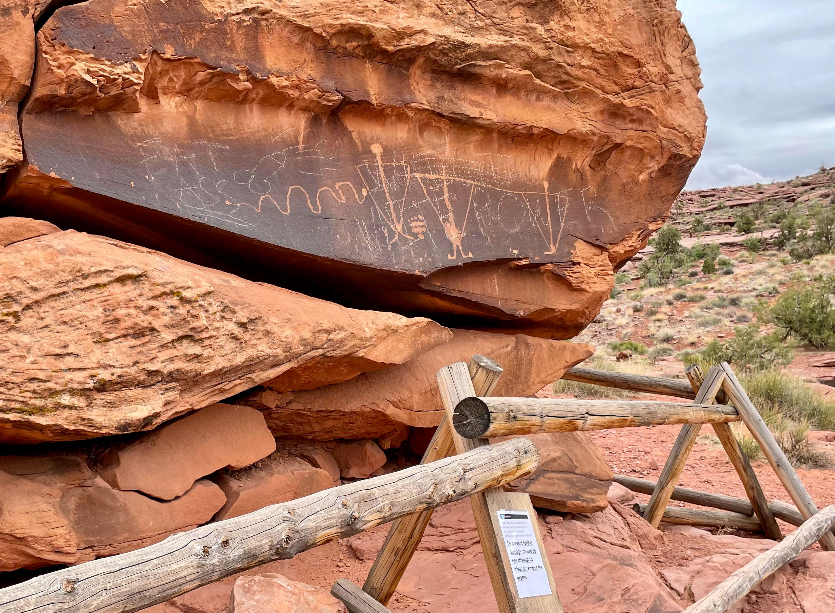 the words "EAT ASS" and "WHITE POWER" drawn over one of the panels of Birthing Rock, apparently in white chalk