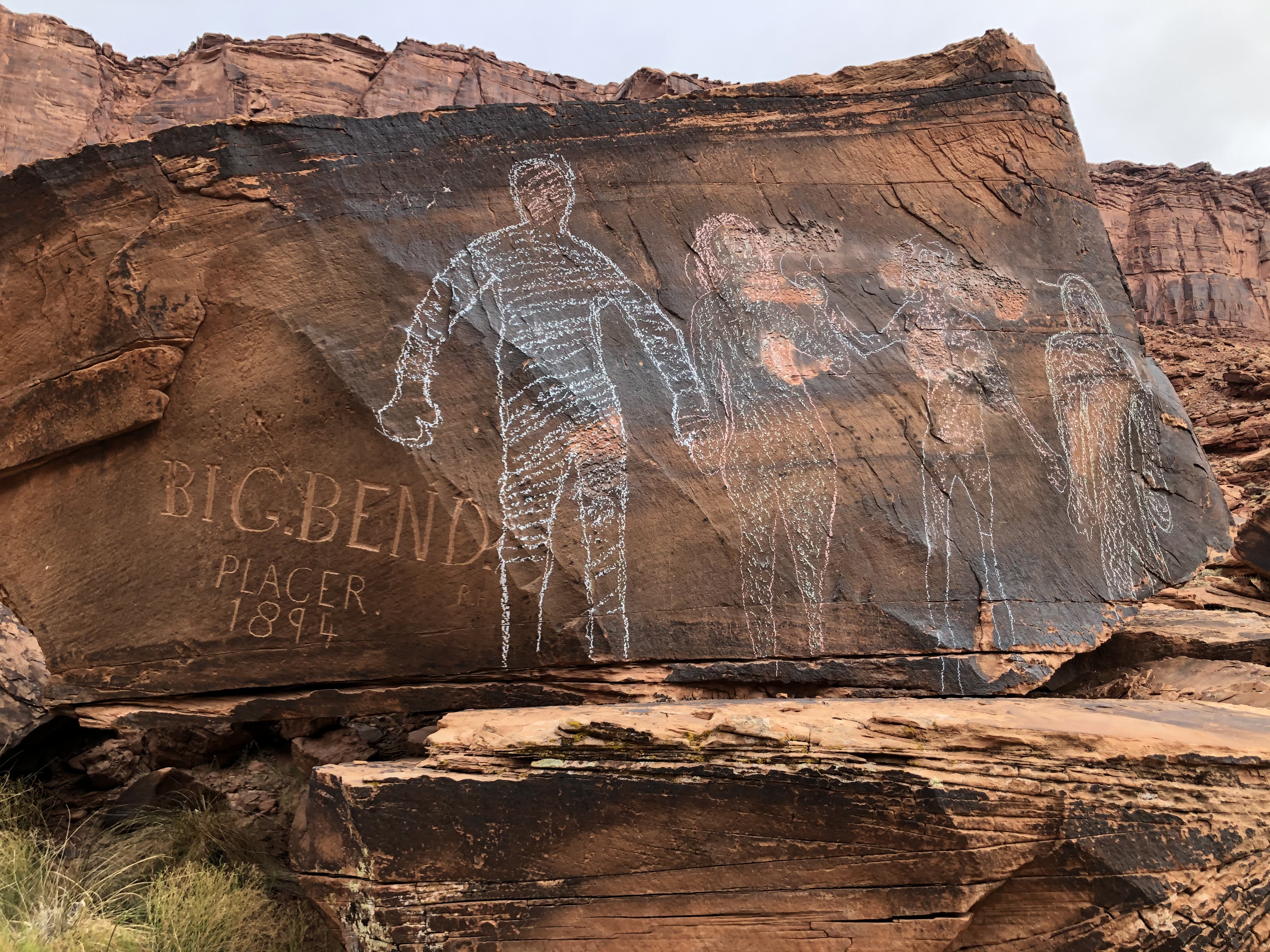 four human figures drawn apparently in chalk next to an inscription at the Big Bend bouldering area off of Highway 128, next to the Colorado River, near Moab, Utah