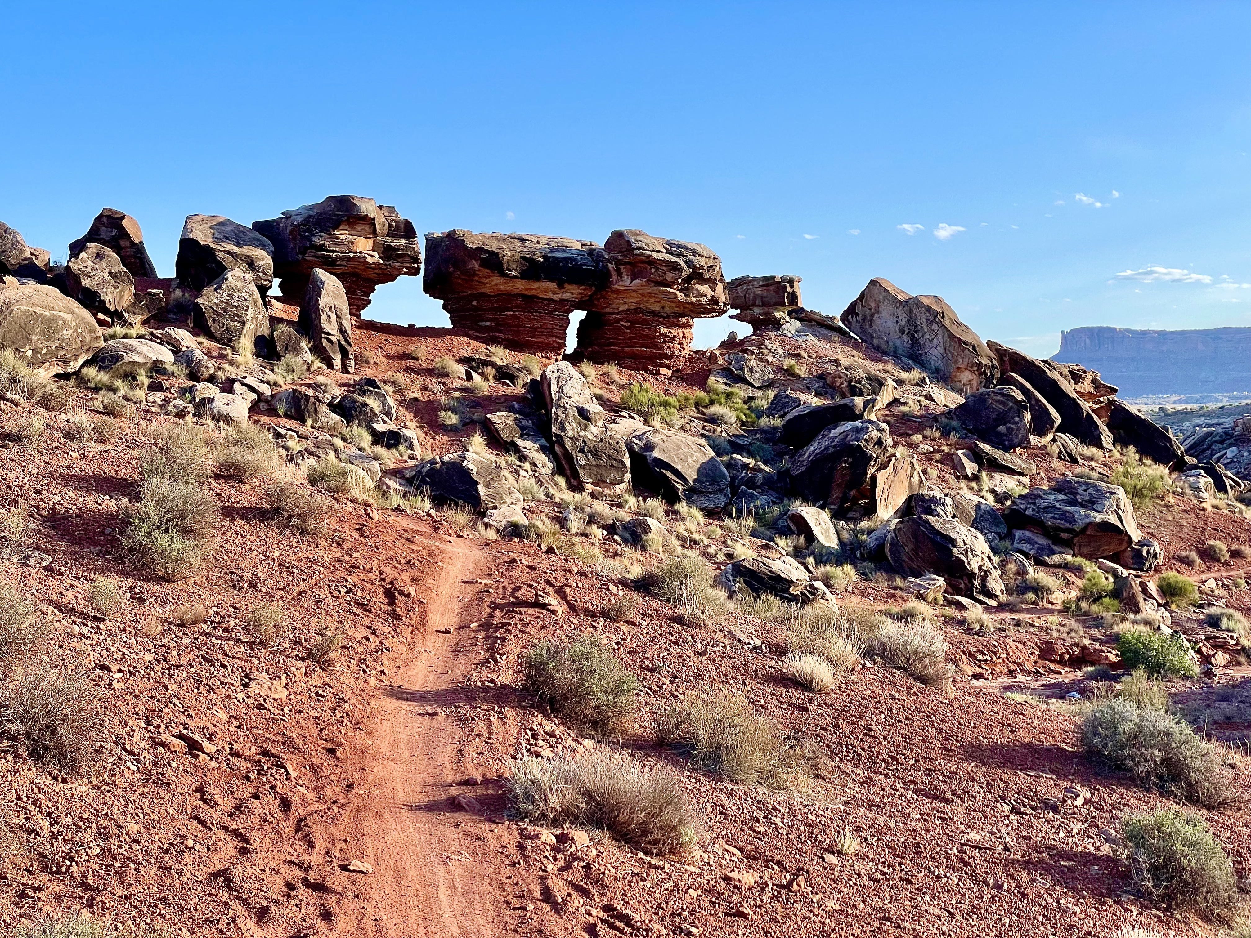 Three boulders sit atop their own sandstone pillars, each roughly 80% the size of the rock on top, in the Klonzo bike network