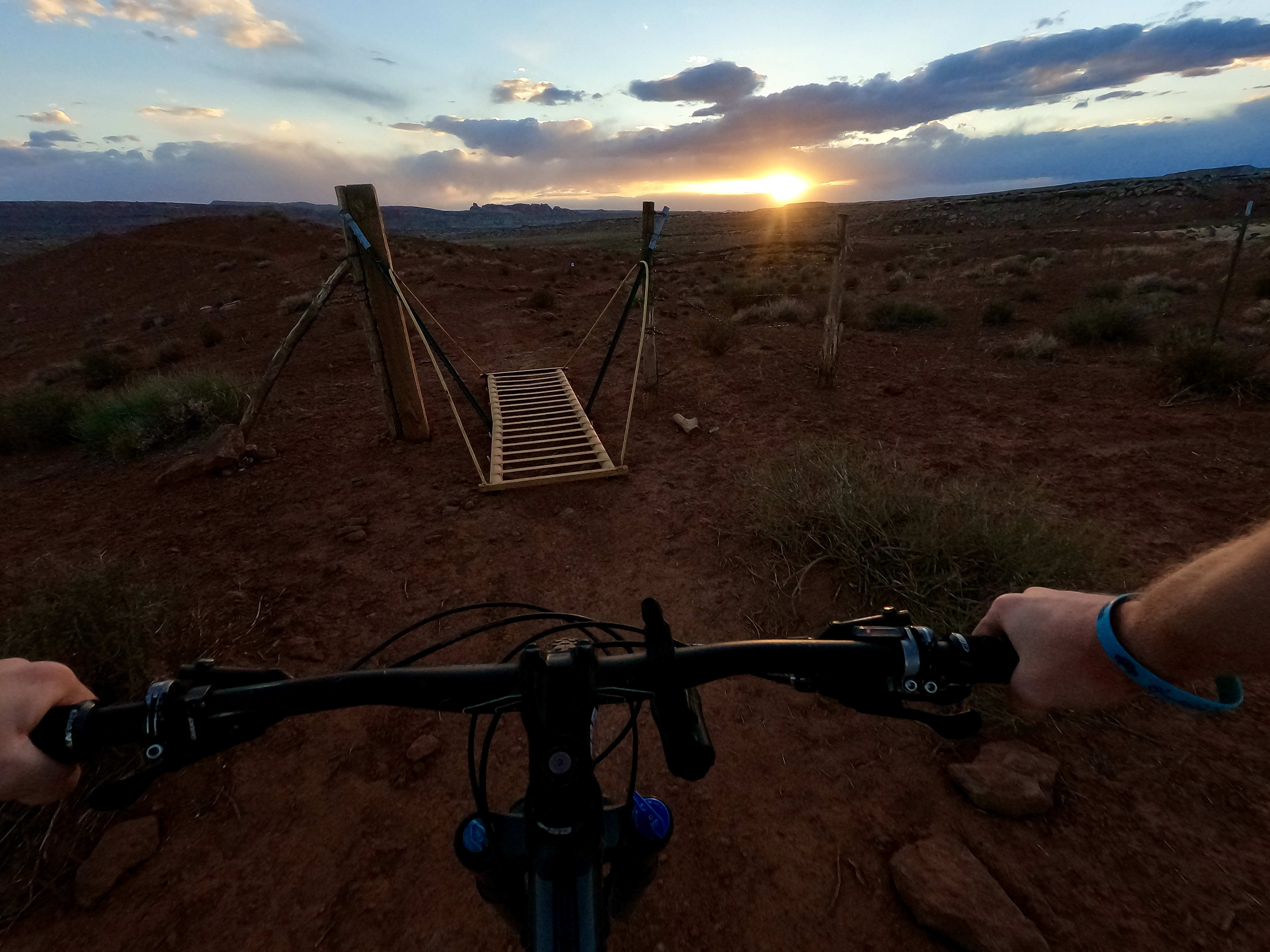 A thin cattle guard sits mid-trail as the sun sets on Hotdog and Redhot, trails that briefly coincide in the southern section of Klonzo