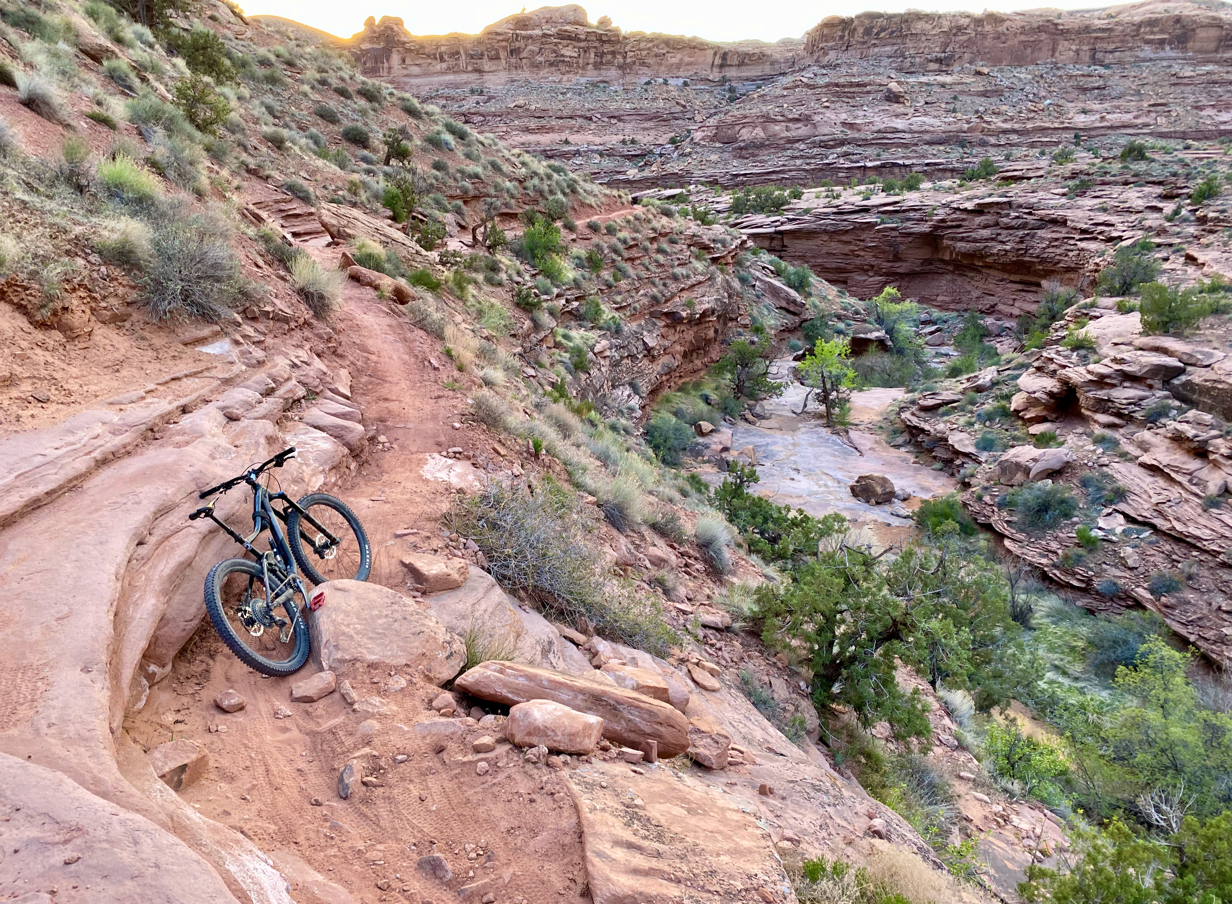 a bike leans on a rock near a wash at the end of Porcupine Rim