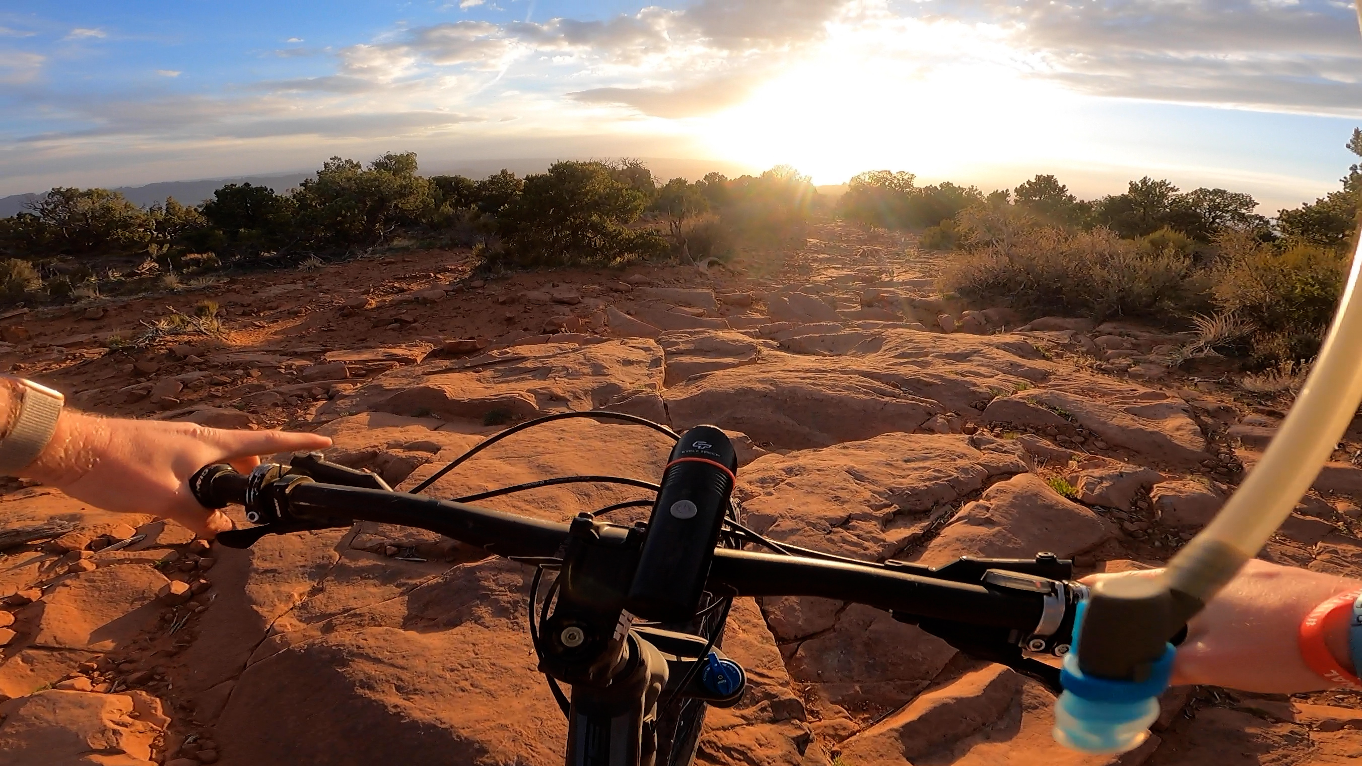 the sun sets on a rocky bit of Porcupine Rim, which glows red in the evening sunlight